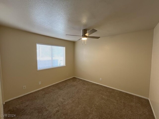 spare room featuring ceiling fan, a textured ceiling, and carpet