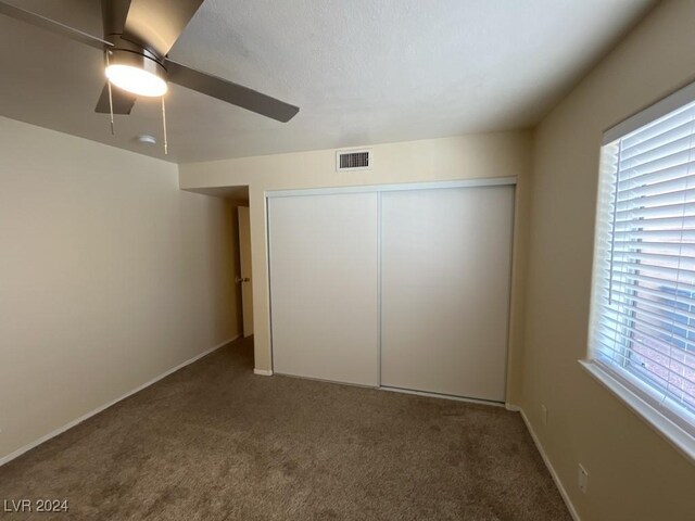 unfurnished bedroom featuring carpet flooring, a closet, and ceiling fan