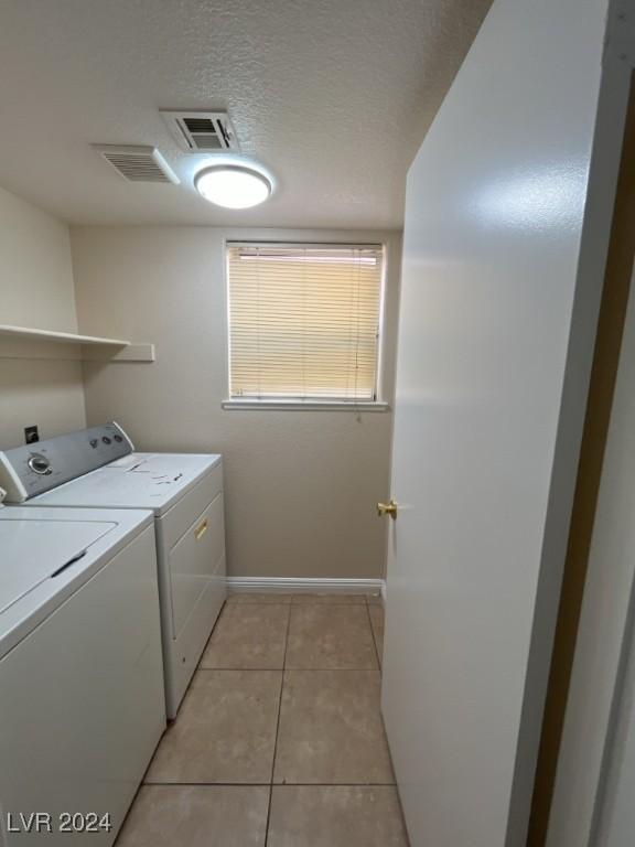 washroom with light tile patterned floors and washer and dryer