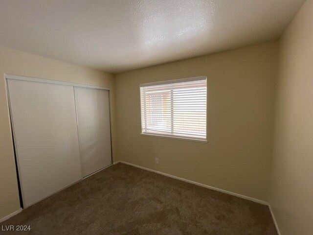 unfurnished bedroom with carpet flooring and a closet