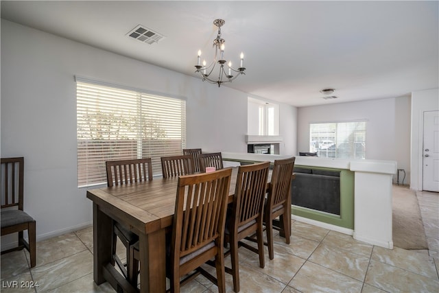 dining area with light tile patterned floors and an inviting chandelier