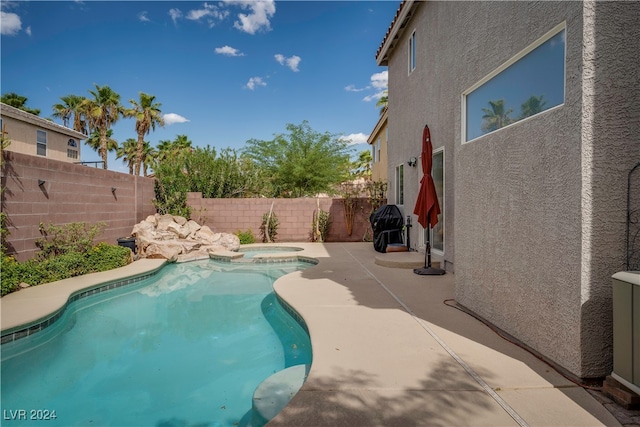 view of swimming pool featuring an in ground hot tub and a patio area