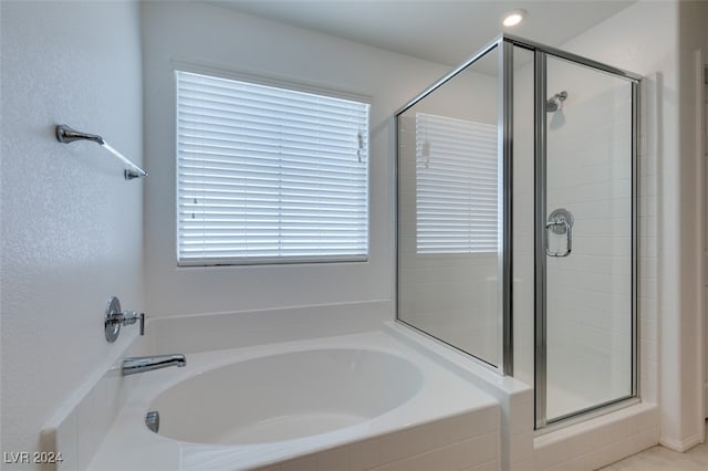 bathroom featuring shower with separate bathtub