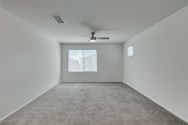 carpeted spare room featuring ceiling fan