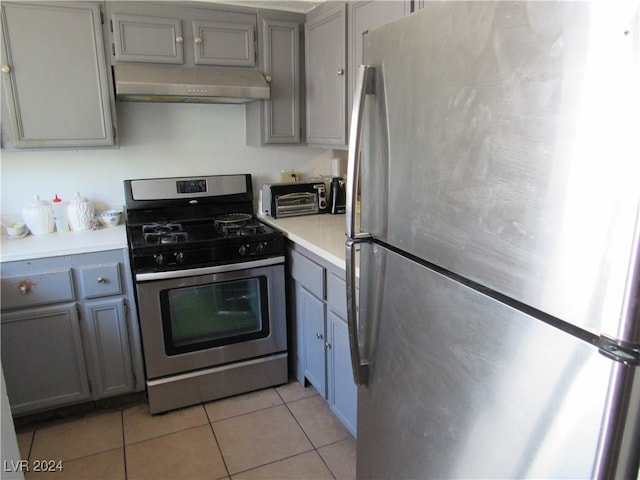 kitchen featuring light tile patterned floors, stainless steel appliances, and gray cabinets