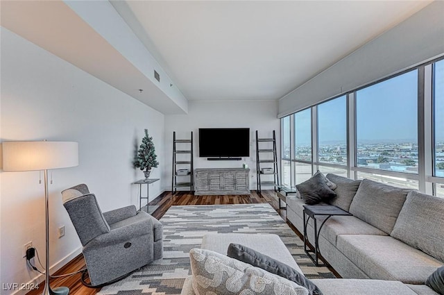 living area with a healthy amount of sunlight, visible vents, and wood finished floors