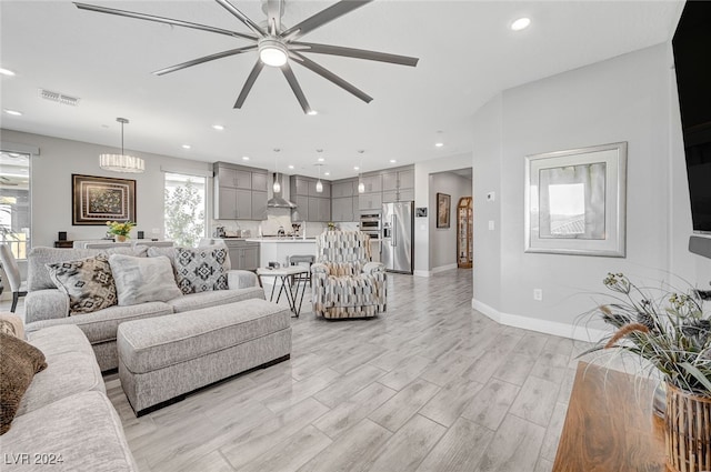 living room featuring ceiling fan with notable chandelier