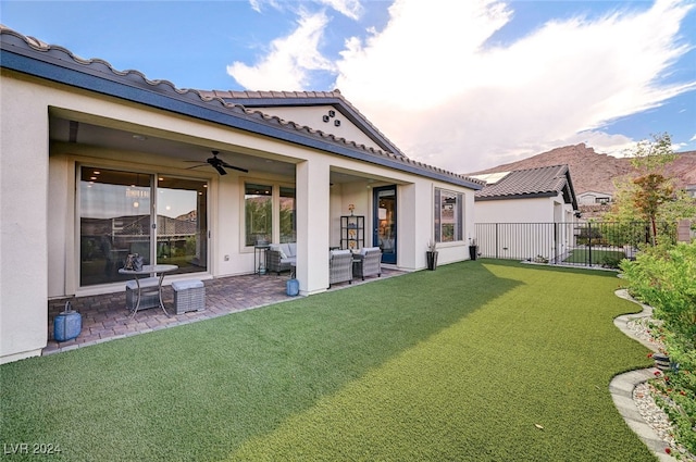 back of house featuring an outdoor hangout area, a patio, ceiling fan, and a lawn