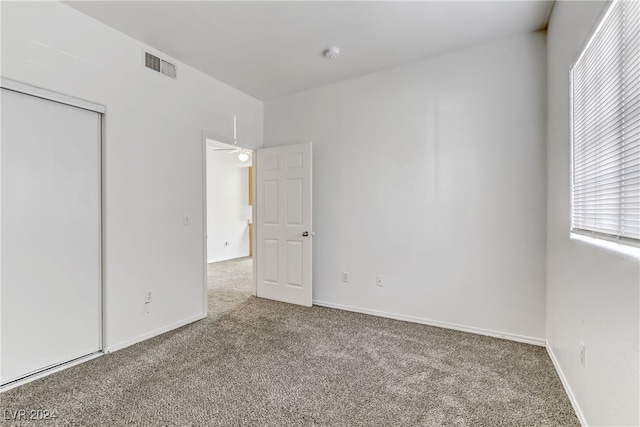 unfurnished bedroom featuring carpet flooring and a closet