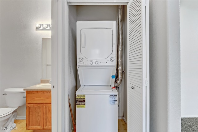 laundry room featuring sink and stacked washing maching and dryer