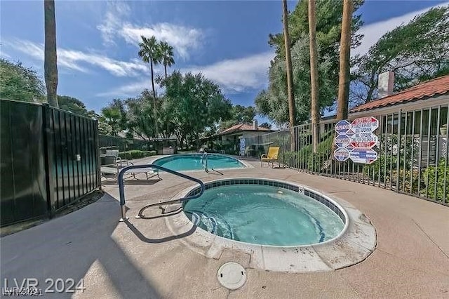 view of pool featuring a community hot tub and a patio