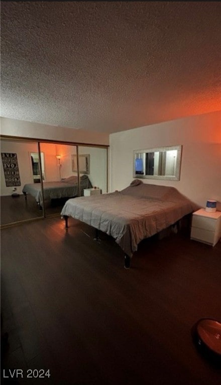 bedroom featuring hardwood / wood-style floors, a closet, and a textured ceiling