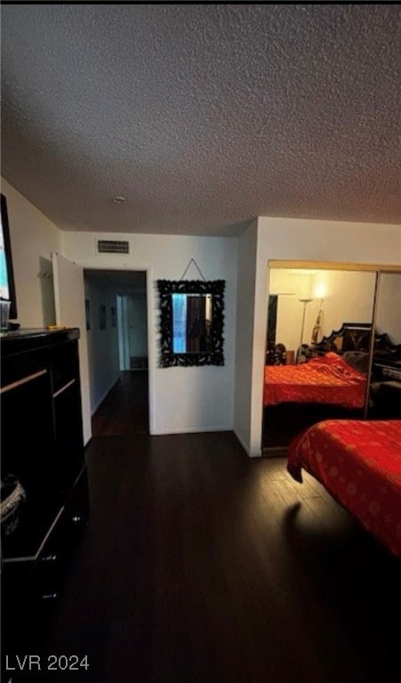 bedroom featuring dark wood-type flooring and a textured ceiling