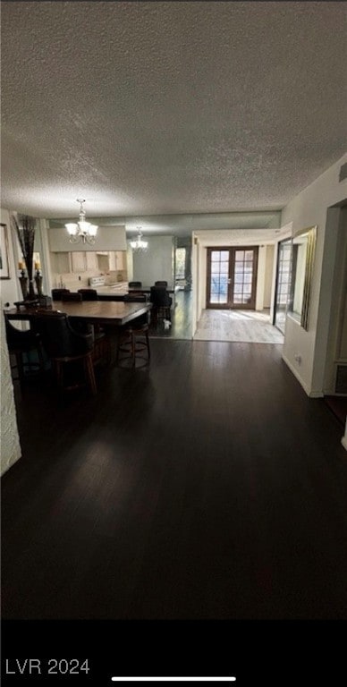 dining space featuring hardwood / wood-style floors, a textured ceiling, and a chandelier