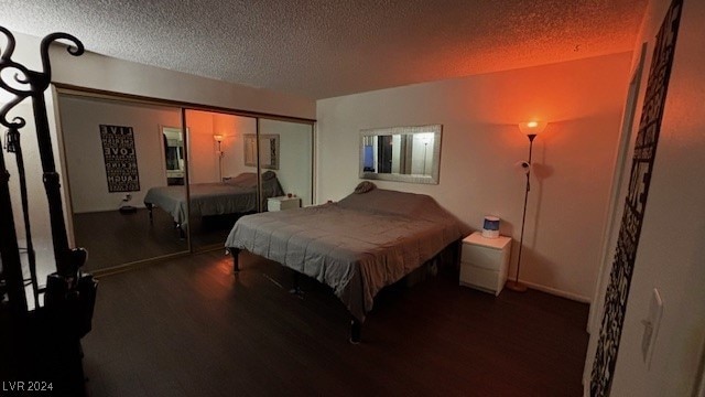 bedroom featuring dark hardwood / wood-style floors, a closet, and a textured ceiling