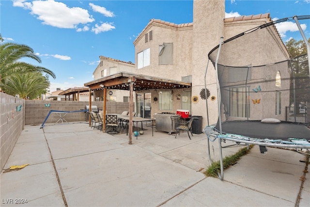 rear view of house with a patio and a trampoline