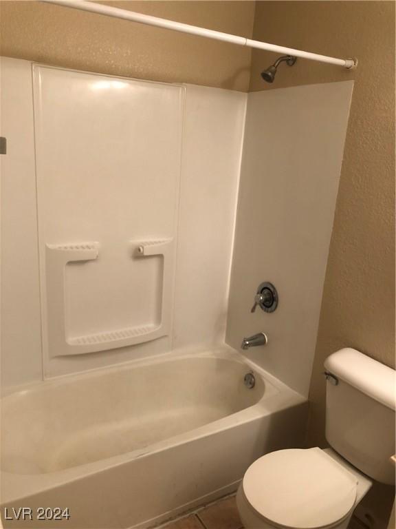 bathroom featuring shower / bathtub combination, toilet, and tile patterned flooring