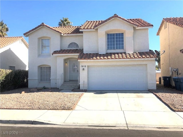 mediterranean / spanish home featuring a garage, concrete driveway, a tiled roof, and stucco siding