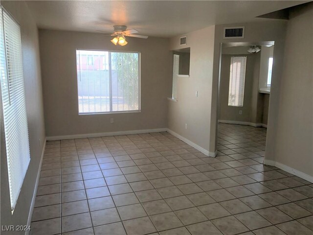 tiled spare room featuring ceiling fan