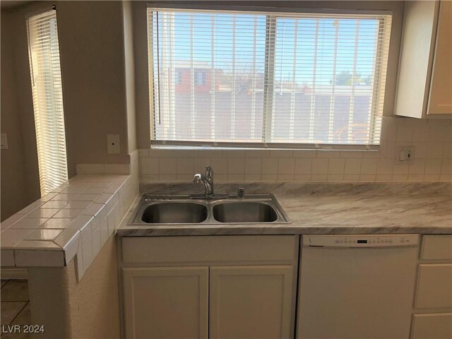 kitchen featuring white cabinetry, tasteful backsplash, sink, tile counters, and white dishwasher