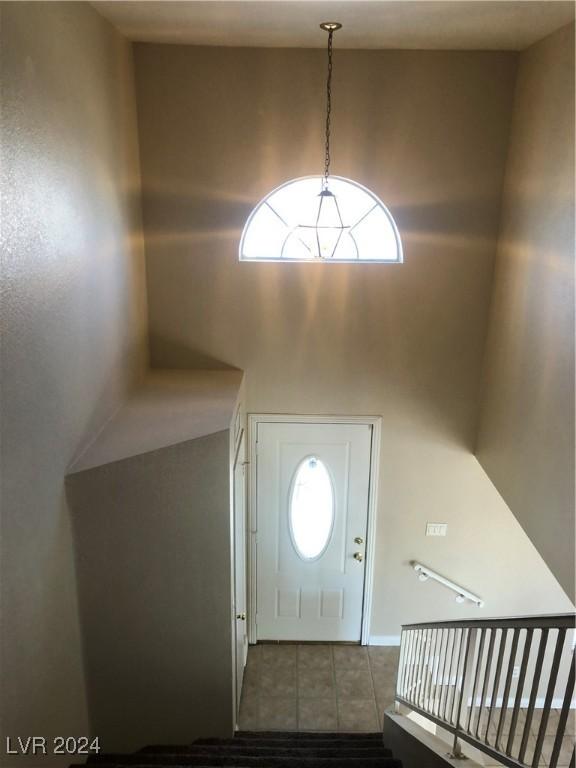 foyer with a high ceiling, plenty of natural light, and light tile patterned flooring