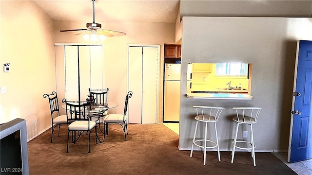 dining space with carpet floors, sink, and ceiling fan