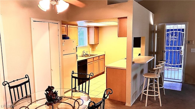 kitchen featuring refrigerator, a kitchen breakfast bar, black dishwasher, and sink