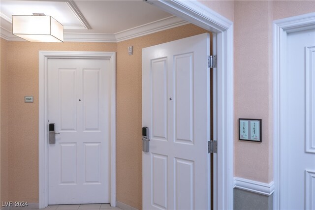 interior space featuring light tile patterned floors and crown molding