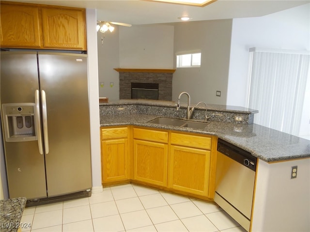 kitchen with a fireplace, stainless steel appliances, sink, kitchen peninsula, and ceiling fan