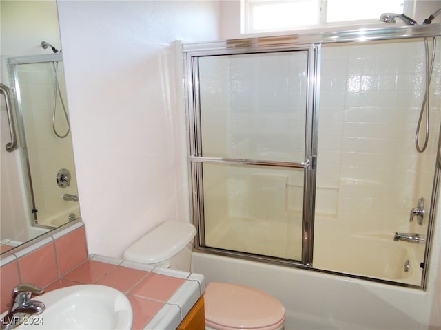 full bathroom with vanity, enclosed tub / shower combo, and toilet