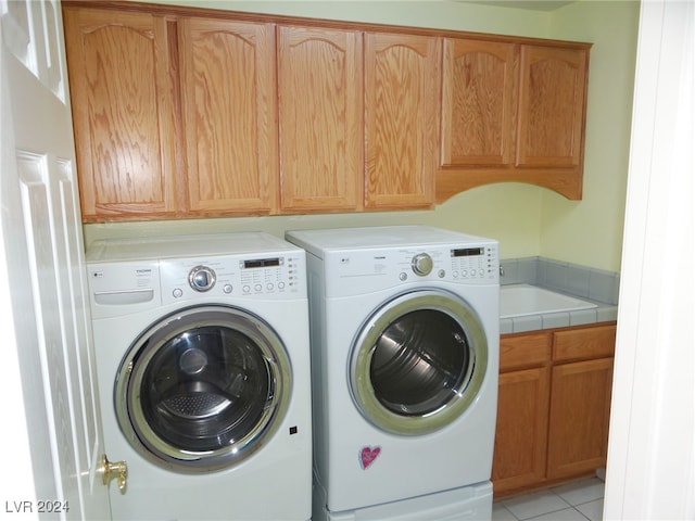 laundry area featuring light tile patterned floors, cabinets, and independent washer and dryer