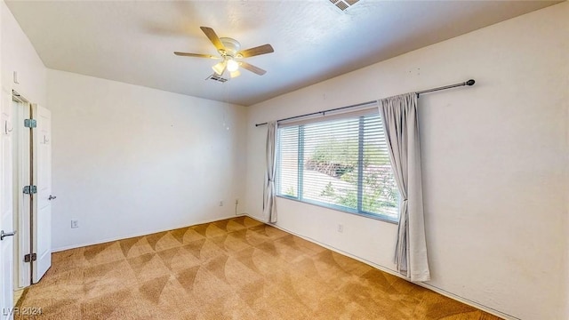 carpeted spare room with ceiling fan