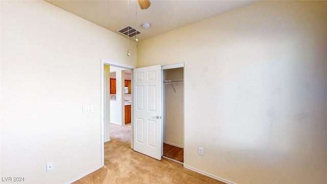 unfurnished bedroom featuring light colored carpet and a closet