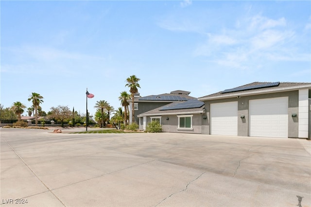 view of front of home with solar panels and a garage