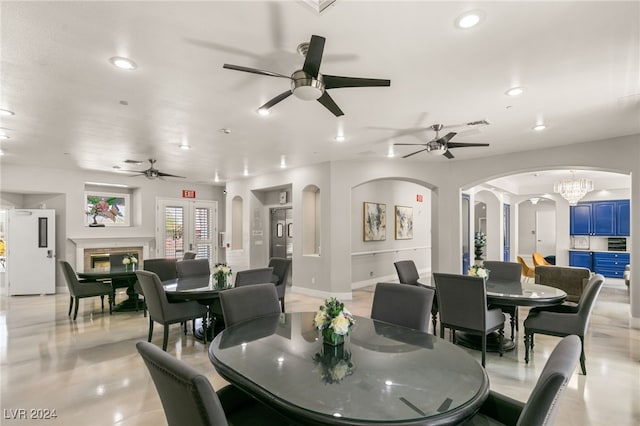 dining space featuring ceiling fan with notable chandelier