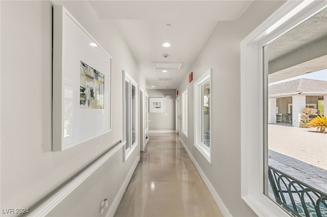 corridor featuring plenty of natural light and concrete flooring