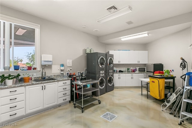 office area with sink and stacked washer and clothes dryer