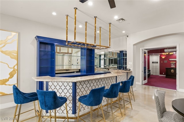 kitchen featuring ceiling fan, a breakfast bar area, and kitchen peninsula