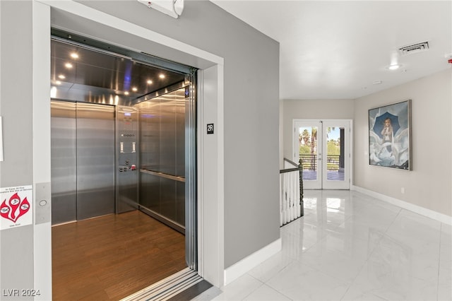 interior space featuring tile patterned flooring, elevator, and french doors