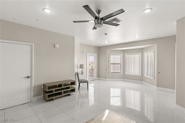 unfurnished living room featuring ceiling fan and light tile patterned floors