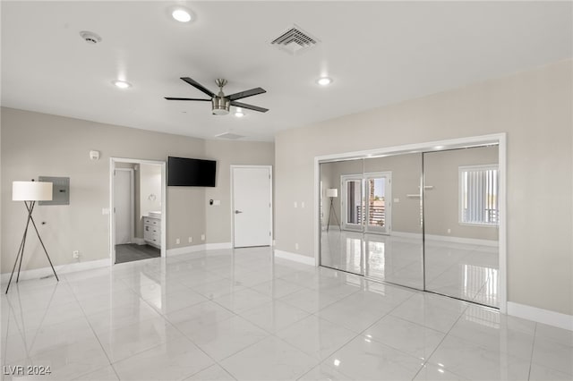 empty room featuring ceiling fan, light tile patterned floors, and electric panel