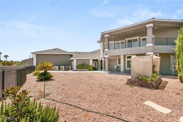 back of property with a balcony and a patio