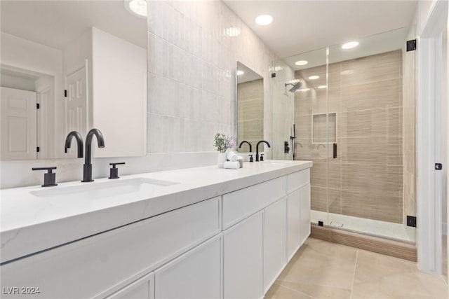 full bath featuring tile patterned floors, a stall shower, double vanity, and a sink