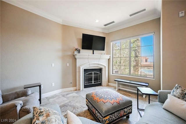 living area with baseboards, a glass covered fireplace, visible vents, and crown molding