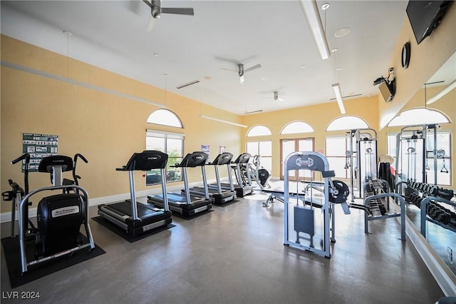 exercise room with ceiling fan and baseboards