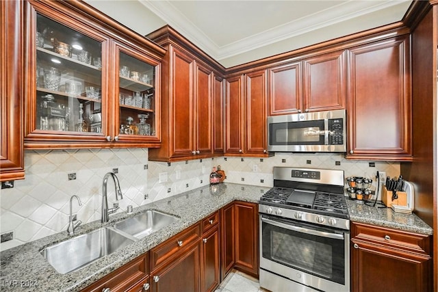 kitchen featuring stainless steel appliances, glass insert cabinets, light stone counters, and a sink