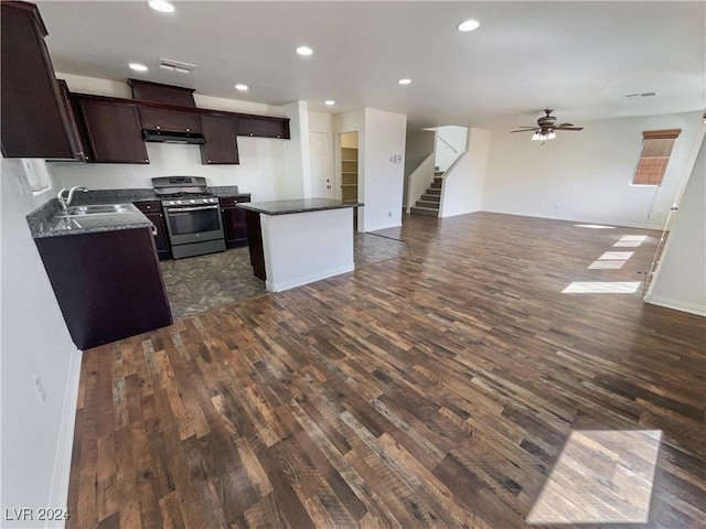 kitchen with a kitchen island, sink, ceiling fan, stainless steel gas range, and dark hardwood / wood-style floors