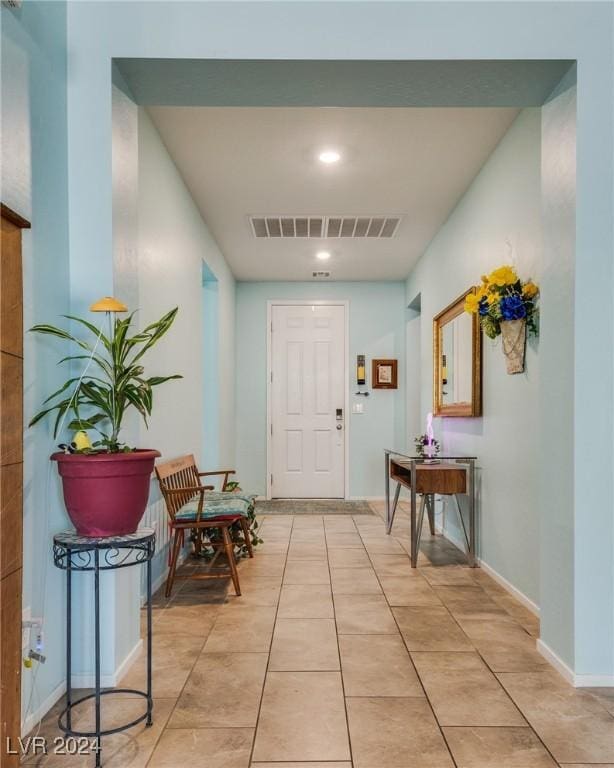 interior space with baseboards, visible vents, and light tile patterned flooring