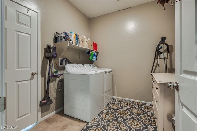 laundry room with light tile patterned floors, laundry area, washing machine and dryer, and baseboards