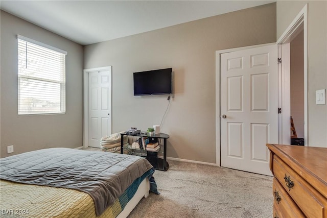 bedroom featuring light colored carpet and baseboards